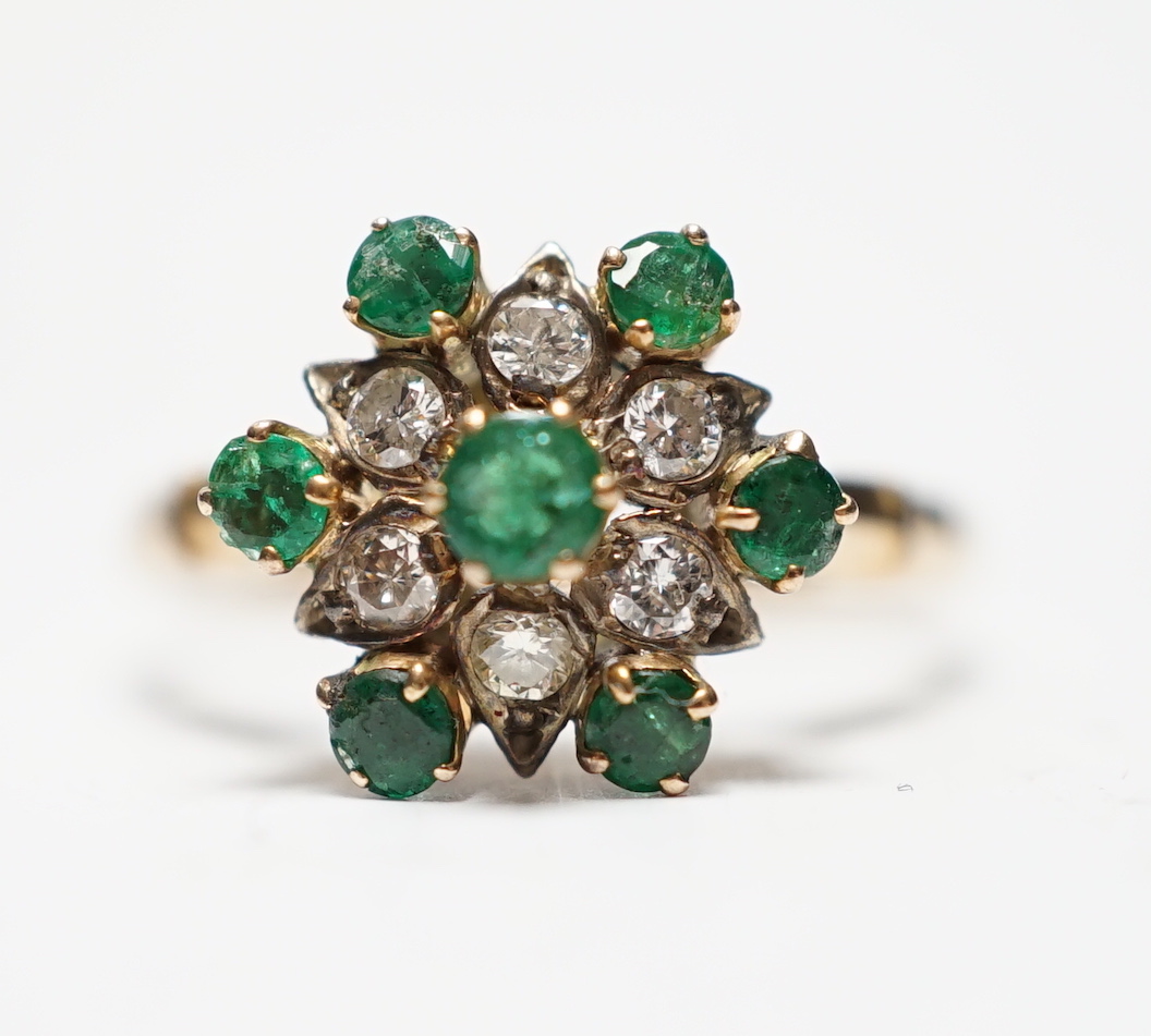 A 14ct, emerald and diamond set flowerhead cluster ring, size N/O, gross weight 3.2 grams.